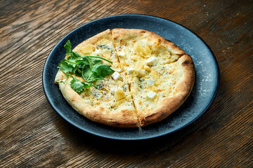 Wood-fired pizza with 4 types of cheese and white sauce with crispy sides, served on a black plate on a wooden background. pizzette a kind of Italian pizza