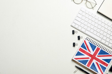 Notepad, keyboard and stationery on white background, flat lay with space for text. Learning English
