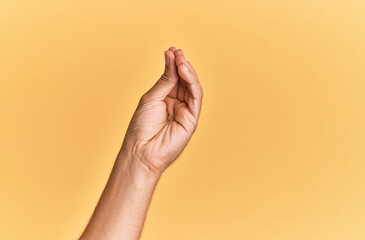 Naklejka premium Arm and hand of caucasian man over yellow isolated background doing italian gesture with fingers together, communication gesture movement