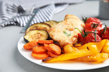 Delicious cooked chicken and vegetables on grey table, closeup. Healthy meals from air fryer