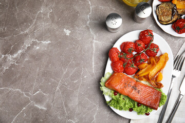 Tasty cooked salmon and vegetables served on grey table, flat lay with space for text. Healthy meals from air fryer