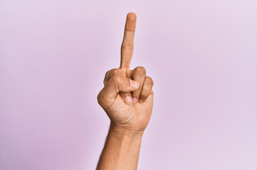Arm and hand of caucasian young man over pink isolated background showing provocative and rude...