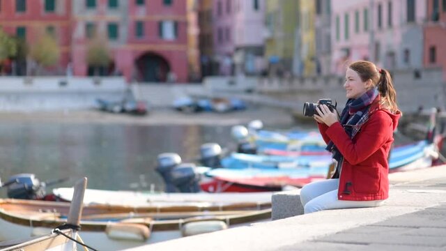 Young female tourist enjoying the view of Vernazza, one of the five centuries-old villages of Cinque Terre, located on rugged northwest coast of Italian Riviera, Liguria, Italy. Traveling off season.