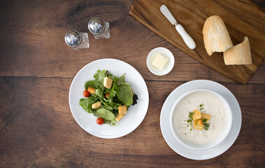 A Bowl of Clam Chowder Soup and a Salad