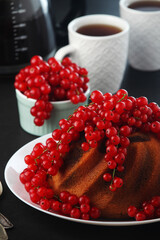 A cake with fresh red currant and tea