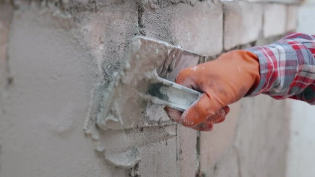 close up of the hand plastering the wall.