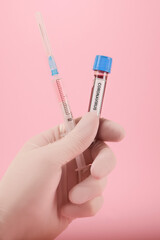 Coronavirus testing tubes in pink background