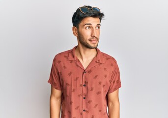 Young handsome man wearing casual summer clothes smiling looking to the side and staring away thinking.