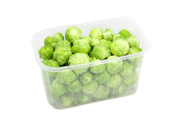 Organic brussels sprouts in disposable plastic container isolated on white background.