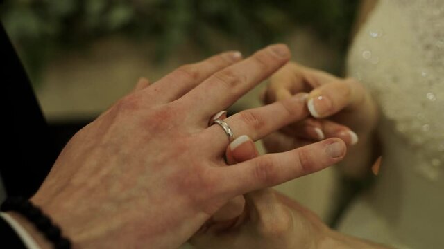 groom and bride exchange wedding rings close-up