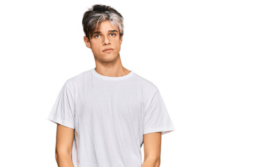 Young hispanic man wearing casual white tshirt with serious expression on face. simple and natural looking at the camera.
