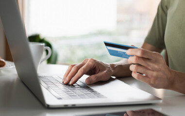 Woman using laptop computer with credit card making online payment. Business, online shopping,...
