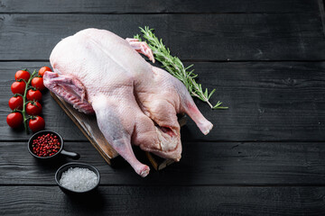 Fresh raw whole duck on black wooden background, with space for text