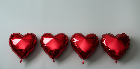 Red heart shaped balloons on grey background. Valentine's Day celebration