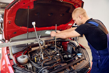 Repairing a car engine in auto-service center. Auto mechanic working in the garage