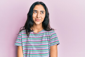 Fototapeta premium Hispanic teenager girl with dental braces wearing casual clothes smiling looking to the side and staring away thinking.