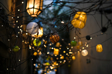 Colorful lampions and lanterns up a tree at night in the garden. A wedding, event or festival...