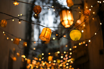 Colorful lampions and lanterns up a tree at night in the garden. A wedding, event or festival...