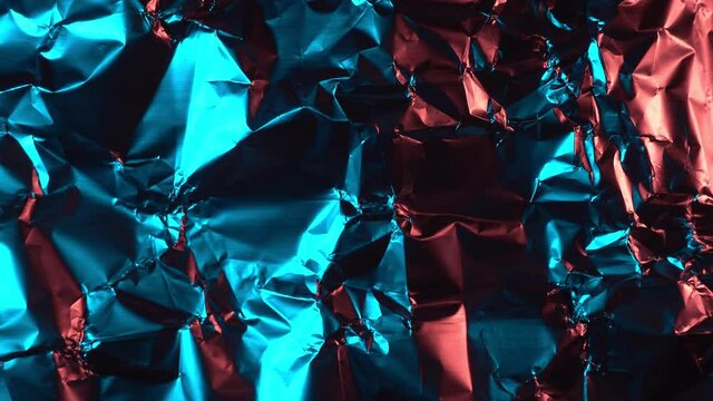 Crumpled foil illuminated with red and blue light. Camera movement. 