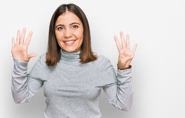 Young beautiful woman wearing casual turtleneck sweater showing and pointing up with fingers number...