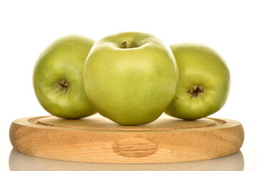 Three organic green apples by Renet Simirenko on a wooden tray, close-up, isolated on white.