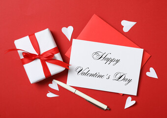 Flat lay composition with greeting card on red background