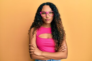 Young latin woman wearing casual clothes and glasses skeptic and nervous, frowning upset because of problem. negative person.