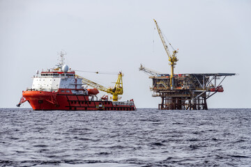 A construction support vessel moored next to a production satellite platfrom while performing an installation project
