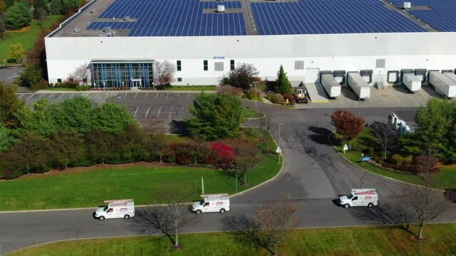 Aerial Shot of Business Vans Turning Down a Street