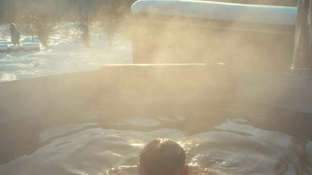 man steamed in a bath in the hot water outdoors