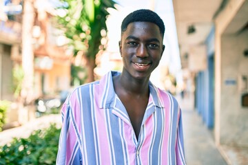 Young african american man smiling happy standing at street of city.