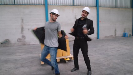 Funny factory workers dance in the factory . Happy people at work .