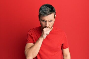 Handsome caucasian man wearing casual red tshirt feeling unwell and coughing as symptom for cold or...
