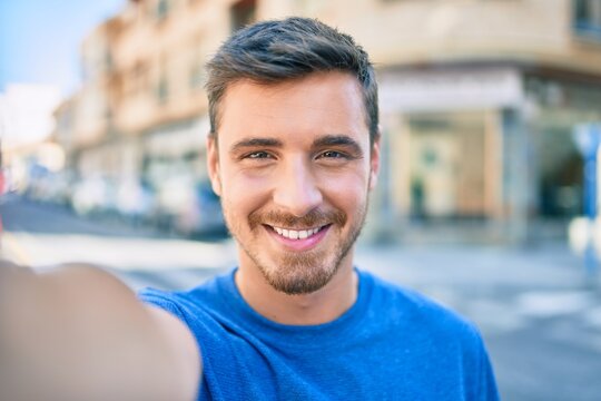 Young caucasian man smiling happy making selfie by the camera at the city.