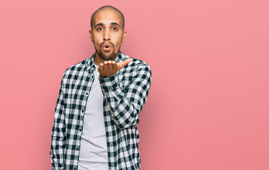 Hispanic adult man wearing casual clothes looking at the camera blowing a kiss with hand on air being lovely and sexy. love expression.