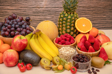 Group Fruits mixed with banana, orange, strawberry and nuts, concept health food and diet, vegetarian food in the top view on the wood table.