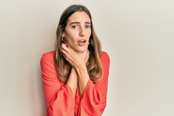 Young beautiful woman wearing casual clothes shouting and suffocate because painful strangle. health problem. asphyxiate and suicide concept.