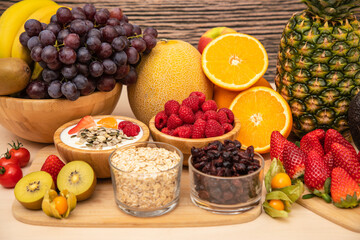 Group Fruits mixed with banana, orange, strawberry and nuts, concept health food and diet, vegetarian food in the top view on the wood table.