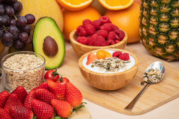 Group Fruits mixed with banana, orange, strawberry and nuts, concept health food and diet, vegetarian food in the top view on the wood table.