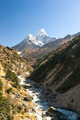 mountain river in the mountains, ama dablam peak on the way to Everest Base Camp, trekking and hiking in Nepal, beautiful landscape in Sagarmatha National Park