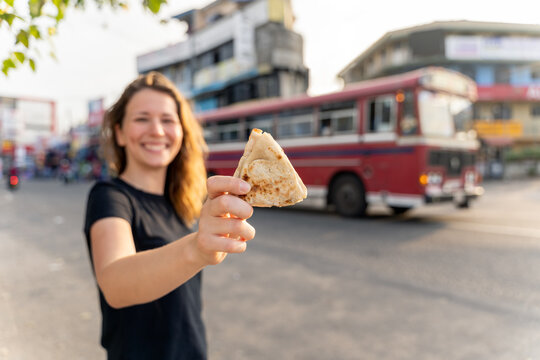 traveler eats vegetable roti in Sri Lankan street foot