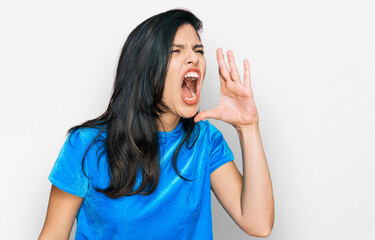 Fototapeta premium Young hispanic woman wearing casual clothes shouting and screaming loud to side with hand on mouth. communication concept.