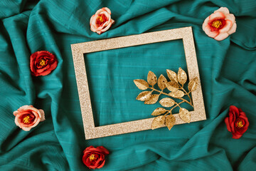 Layout of gold leaves with  shiny frame and rose flowers. Creative cyan background. Minimal Valentines day concept