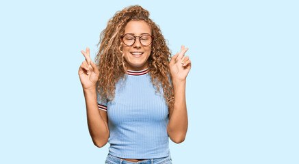 Fototapeta na wymiar Beautiful caucasian teenager girl wearing casual clothes and glasses gesturing finger crossed smiling with hope and eyes closed. luck and superstitious concept.