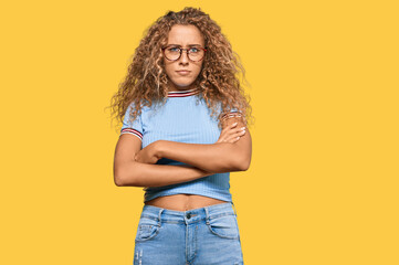 Beautiful caucasian teenager girl wearing casual clothes and glasses skeptic and nervous, disapproving expression on face with crossed arms. negative person.