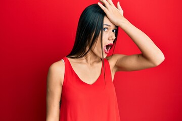 Young hispanic girl wearing casual style with sleeveless shirt surprised with hand on head for mistake, remember error. forgot, bad memory concept.