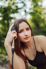 Fototapeta premium Girl with microphone in the summer garden