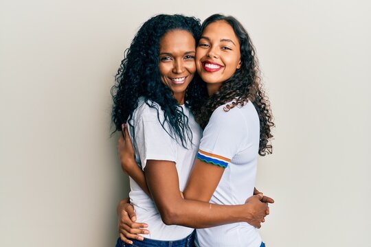 African american mother and daughter wearing casual white tshirt looking positive and happy standing and smiling with a confident smile showing teeth