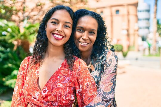African american mother and daughter smiling happy hugging at the park.