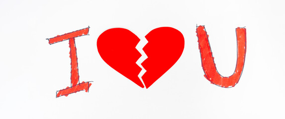 A man in white holds a sign showing his broken love.